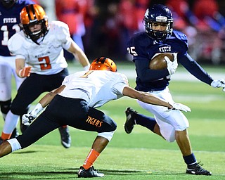 AUSTINTOWN, OHIO - OCTOBER 2, 2015: Randy Smith #25 of Fitch runs the football away from Jeff Kock #1 of Massillon during their game Friday night at Fitch Falcons Stadium. DAVID DERMER | THE VINDICATOR