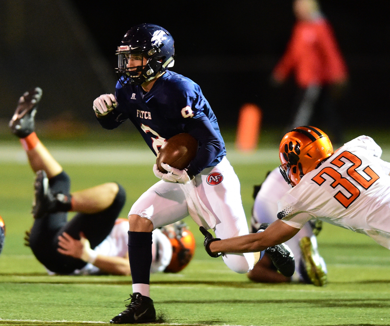 AUSTINTOWN, OHIO - OCTOBER 2, 2015: Nate Fowler #8 of Fitch runs the football away from the arm tackle of Kordell Ford #32 of Massillon during their game Friday night at Fitch Falcons Stadium. DAVID DERMER | THE VINDICATOR
