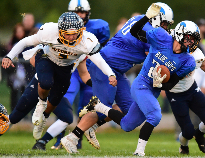 NORTH JACkSON, OHIO - OCTOBER 2, 2015: Joseph Burnside #24 of Jackson Milton runs the football away from Ben Carkido #7 of McDonald during the 1st half of their game at Jackson Milton Stadium Friday night. DAVID DERMER | THE VINDICATOR