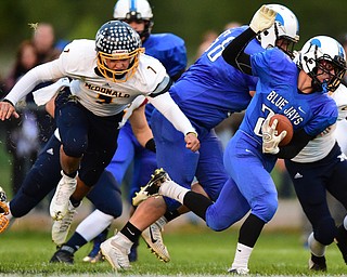 NORTH JACkSON, OHIO - OCTOBER 2, 2015: Joseph Burnside #24 of Jackson Milton runs the football away from Ben Carkido #7 of McDonald during the 1st half of their game at Jackson Milton Stadium Friday night. DAVID DERMER | THE VINDICATOR