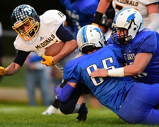 NORTH JACkSON, OHIO - OCTOBER 2, 2015: Joe Perry #15 of McDonald is tackled by Connon Kleinknecht #85 and Mason Mercer #58 of Jackson Milton during the 1st half of their game at Jackson Milton Stadium Friday night. DAVID DERMER | THE VINDICATOR