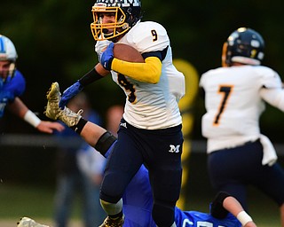 NORTH JACkSON, OHIO - OCTOBER 2, 2015: Jake Reckard #9 of McDonald runs the football after jumping over Cameron Shaffer #52 of Jackson Milton during the 1st half of their game at Jackson Milton Stadium Friday night. DAVID DERMER | THE VINDICATOR