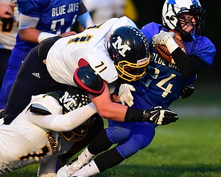 NORTH JACkSON, OHIO - OCTOBER 2, 2015: Joseph Burnside #24 of Jackson Milton is tackled by Drew Butler #71 and Ben Carkido #7 of McDonald during the 1st half of their game at Jackson Milton Stadium Friday night. DAVID DERMER | THE VINDICATOR
