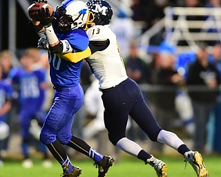 NORTH JACkSON, OHIO - OCTOBER 2, 2015: Adam Smith #80 of Jackson Milton catches a pass for a 1st down while being tackled by Dylan Portolese #13 of McDonald during the 1st half of their game at Jackson Milton Stadium Friday night. DAVID DERMER | THE VINDICATOR