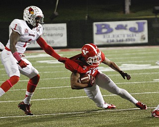        ROBERT K. YOSAY  | THE VINDICATOR..Redbirds #1  does a jersey tackle on #20 YSU Jody Webb  as he is stopped at the line