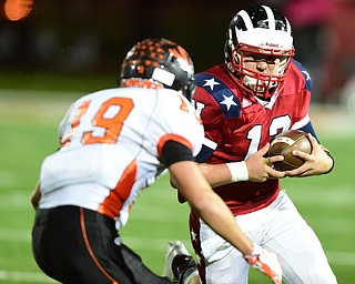 NILES, OHIO - OCTOBER 15, 2015: Tyler Srbinovich #13 of Niles runs the football before being hit by Keith Rounds #19 of Howland during the 1st half of a game at Niles High School on Thursday night. DAVID DERMER | THE VINDICATOR