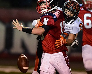 NILES, OHIO - OCTOBER 15, 2015: Tyler Srbinovich #13 of Niles fumbles the football while being sacked by Victor Williams #20 of Howland during the 1st half of a game at Niles High School on Thursday night. DAVID DERMER | THE VINDICATOR