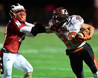 NILES, OHIO - OCTOBER 15, 2015: Victor Williams #20 of Howland stiff arms Zach Vaughn #27 of Niles during the 2nd half of a game at Niles High School on Thursday night. DAVID DERMER | THE VINDICATOR
