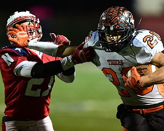 NILES, OHIO - OCTOBER 15, 2015: Victor Williams #20 of Howland stiff arms Zach Vaughn #27 of Niles during the 2nd half of a game at Niles High School on Thursday night. DAVID DERMER | THE VINDICATOR