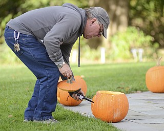 Katie Rickman | The Vindicator.Dennis Penner, Garden Supervisor for Mill Creek MetroParks lights a candle inside a jack-o'-lantern during the 12th Annual Pumpkin Walk at Twilight at Fellows Riverside Gardens Sunday evening.