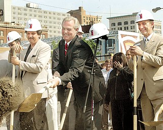 The Vindicator/William D. LewisPROJECT BEGINS: Youngstown Mayor George M. McKelvey throws a shovel of dirt to mark the ceremonial start on June 22, 2004 of construction on the $41 million downtown arena project. At left is Councilman Michael Rapovy, D-5th, and at right is Rick Kozuback, president and chief executiveof Global Entertainment of Phoenix, which is building and managing the arena.