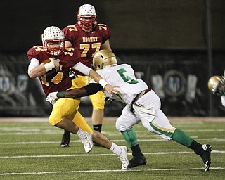        ROBERT K. YOSAY  | THE VINDICATOR..Mooneys #14  Jack Lynch Eludes Ursulines #5 Ty Spinks as he goes for a first down Mooney #77 Nick Maxin watches- first quarter action..Ursuline vs Mooney at Stambaugh Stadium...-30-
