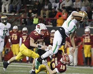        ROBERT K. YOSAY  | THE VINDICATOR..Second quarter action as Ursulines #13 Jared Fabry leaps over Mooney defender  #18  Patrick Pelini   and Nick  Bucci that set up a score for mooney.. Ursuline vs Mooney at Stambaugh Stadium...-30-