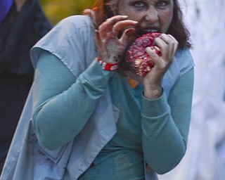 Katie Rickman | The Vindicator.Amy Rigby of Youngstown stumbles over the Spring Commons Bridge acting the part of a zombie eating a "brain" during the fifth annual Zombie Crawl at the B&O in Youngstown on Saturday evening.