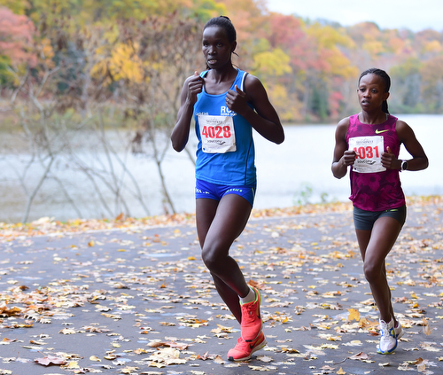 YOUNGSTOWN, OHIO - OCTOBER 25, 2015: Hellen Jepkurhat sprints infront of Monicah Ngige as they both pass in front of Lake Glacier inside Mill Creek Park during the Peace Race Sunday morning. DAVID DERMER | THE VINDICATOR