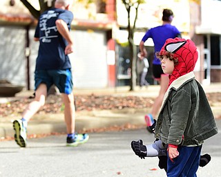 YOUNGSTOWN, OHIO - OCTOBER 25, 2015: Owen Papini 4, of Boardman watches runners jog toward the finish line along West Federal Street during the Peace Race Sunday morning. DAVID DERMER | THE VINDICATOR