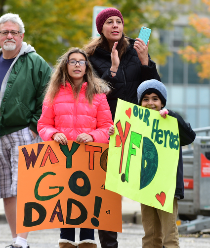YOUNGSTOWN, OHIO - OCTOBER 25, 2015: Roseanne Hoffman (back) and her kids Sofia (left) and Alex (right) wait for Brian Hoffman to reach the finish line on West Federal Street during the Peace Race Sunday morning. DAVID DERMER | THE VINDICATOR
