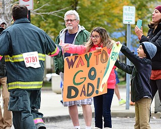 YOUNGSTOWN, OHIO - OCTOBER 25, 2015: Brian Hoffman of Boardman gives his daughter Sofia a high five while getting words of encouragement from his son Alex and wife Roseanne as he jogs towards the finish line during the Peace Race Sunday morning. DAVID DERMER | THE VINDICATOR