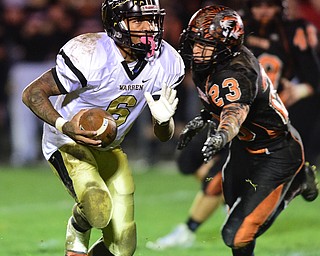 HOWLAND, OHIO - OCTOBER 30, 2015: Lynn Bowden #6 of Harding runs into the open field after side stepping Steve Baugh #23 of Howland in the backfield during the 1st half of a game Friday night at Howland High School. DAVID DERMER | THE VINDICATOR..