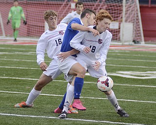 Katie Rickman | The Vindicator.Canfield's  Sam Accordino (#18) keeps control of the ball despite efforts by Poland's Joseph Shields (#10) attempt to block him during the game in Niles on Saturday night. Canfield's Tyler Young (#16) assists Accordino.