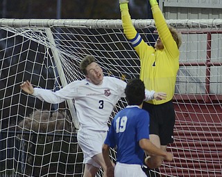 Katie Rickman | The Vindicator.Poland's goal keeper Bryan Montgomery (#1) jumps in the air and catches a failed attempt by Canfield to score as Canfield's RJ Thomas (#3) jumps in the air beside him.