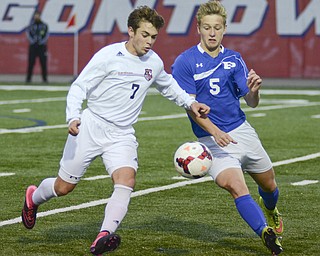 Katie Rickman | The Vindicator.Canfield's Christian Hume (#7) keeps control of the ball as Poland's Marcus Revis (#5) comes up from behind during the game in Niles on Saturday night.