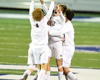 SANDUSKY, OHIO - NOVEMBER 11, 2015: Cole Frank #3 of South Range is hugged by his teammates Brooks Thomas #1, Landon Baer #6, and Charlie Staffeld #5 after a Archbold own goal on a Frank free kick during the 2nd half of Wednesday nights State Semi-Final game at Cedar Point Stadium. Out Range won 1-0. DAVID DERMER | THE VINDICATOR