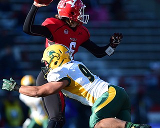 YOUNGSTOWN, OHIO - NOVEMBER 14, 2015: Hunter Wells #6 of YSU throws a pass for a first down while being hit by Greg Menard #96 of North Dakota State during the 1st half of their game at Stambaugh Stadium Saturday afternoon. DAVID DERMER | THE VINDICATOR