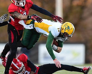 YOUNGSTOWN, OHIO - NOVEMBER 14, 2015: Eason Stick #12 of North Dakota State is brought down aggressively by LeRoy Alexander #3 and Nate Dortch #8 of YSU during the 2nd half of their game at Stambaugh Stadium Saturday afternoon. DAVID DERMER | THE VINDICATOR