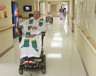 William D. Lewis The Vindicator Rev. Steve Popovich navigates his wheelchair to mass at Liberty Healthcare and Rehab. Popovich was paralized in a car crash.