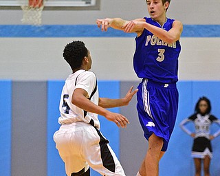 YOUNGSTOWN, OHIO - DECEMBER 4, 2015: Mike Gajdos #3 of Poland flies through the air while passing the ball to a teammate over Ceandre Backus #5 of East during the 2nd half of their game Friday night at East High School. DAVID DERMER | THE VINDICATOR