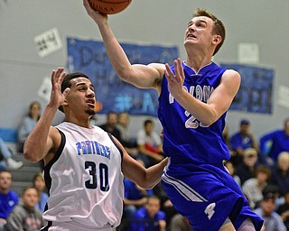 YOUNGSTOWN, OHIO - DECEMBER 4, 2015: Jared Burkert #23 of Poland lays the ball into the basket while being pressured by Moises Dumeng #30 of East during the 2nd half of their game Friday night at East High School. DAVID DERMER | THE VINDICATOR