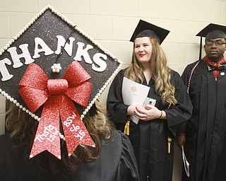 William D. Lewis the Vindicator Trista Goss of Youngstown uses her motar board to say she has a lot to be thankful for as she graduated from YSU with a bachelor in Social Work Sunday. Looking on are fellow grads Amy Van Fossan of Boardman and Kevin R. Wallace of Youngstown.