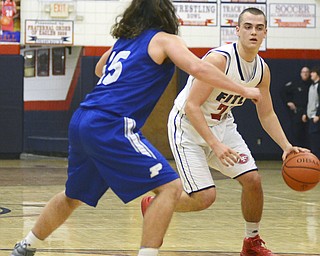 Katie Rickman | The Vindicator. Fitch's Brian Beany (#33) moves up the court around Poland's Nick Buccieri (#15)the third period of the game at Fitch High School on Tuesday night.