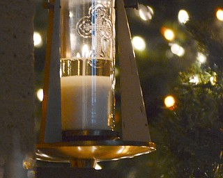 Katie Ricman | The Vindicator.A candle is lit as Christmas lights glow on a tree at St. Catherine Church in Lake Milton on December 22, 2015.