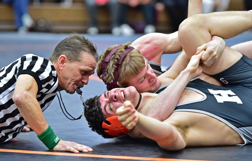 HOWLAND, OHIO - DECEMBER 23, 2015: Jimmy Sferra of Boardman works to pin Shawn Carr of Howland while being watched by referee Mike Glass  during a 145lb bout Wednesday afternoon at Howland High School. DAVID DERMER | THE VINDICATOR