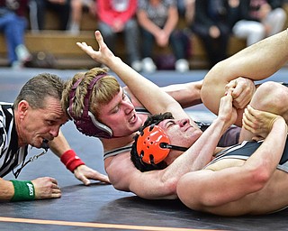 HOWLAND, OHIO - DECEMBER 23, 2015: Jimmy Sferra of Boardman works to pin Shawn Carr of Howland while being watched by referee Mike Glass  during a 145lb bout Wednesday afternoon at Howland High School. DAVID DERMER | THE VINDICATOR