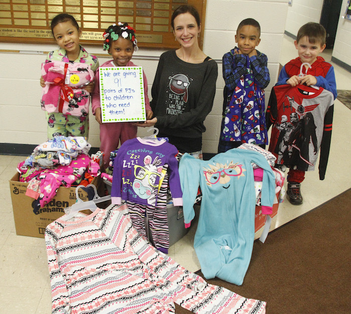Students from Akiva Academy at the Jewish Community Center in Youngstown collected more than 91 pairs of pajamas that will be given to
Mahoning County needy children. The children had a dress-down pajama party Thursday to celebrate their achievement. Showing off some
of the pajamas are, from left, Alena Scott and Sha Kei Jones, both fi rst-graders; Shauna Kraff t , third-grade teacher who spearheaded the
project; and kindergartners Rodney Dukes and Drew Nemetz 
