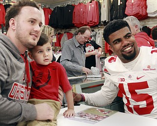 William D Lewis the vindicator  Curtis Flaviani and his son Eli, 2, of Niles pose for a photo with OSU star Ezekiel Elliott during a 1-9-167 event at the Eastwood Mall in Niles.