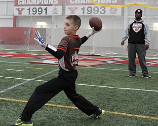 Ashton O'Brien prepares to pass the ball during practice for the 9-10 year old YYFFA team while president Elliot Giles watches on Wednesday night at the WATTS.  Dustin Livesay  |   The Vindicator  1/13/16  YSU, WATTS