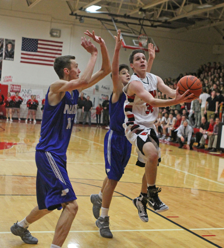 Canfield's Julian Vitto (32) goes up for a layup while being defended by Poland's Matt Baker (11) and Braeden O'Shaugnessy (20) during Friday nights matchup at Canfield High School.  Dustin Livesay  |  The Vindicator  1/29/16  Canfield High School.