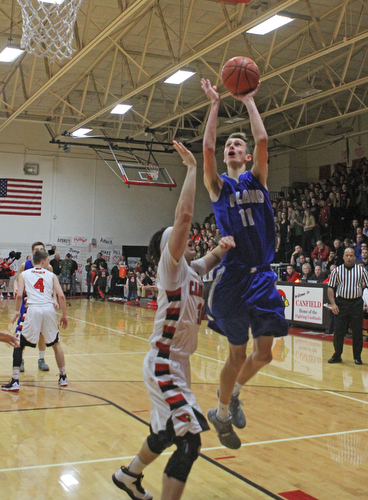 Poland's Matt Baker (11) goes up for a shot while being defended by Canfield's Vince Ferrier (31) during Friday nights matchup at Canfield High School.  Dustin Livesay  |  The Vindicator  1/29/16  Canfield High School.