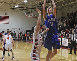 Poland's Matt Baker (11) goes up for a shot while being defended by Canfield's Vince Ferrier (31) during Friday nights matchup at Canfield High School.  Dustin Livesay  |  The Vindicator  1/29/16  Canfield High School.