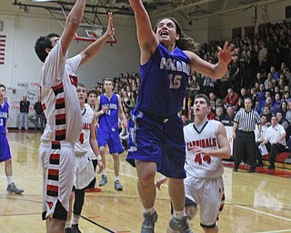 Poland's Nick Buccieri (15) goes in for a layup while being defended by Canfield's Sam Digiacomo (42) during Friday nights matchup at Canfield High School.  Dustin Livesay  |  The Vindicator  1/29/16  Canfield High School.