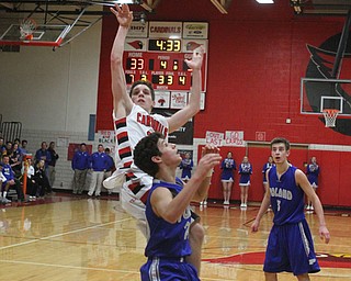 Canfield's Julian Vitto (32) takes a jump shot while being defended by Poland's Braeden O'Shaugnessy (20) during Friday nights matchup at Canfield High School.  Dustin Livesay  |  The Vindicator  1/29/16  Canfield High School.