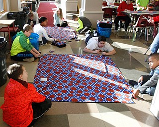      ROBERT K. YOSAY  | THE VINDICATOR..Some of the bigger blankets had to be done on the floor ...St. Charles School students huddled around tables in the cafeteria busying themselves with measuring, cutting and tying for a good cause..The fifth-through-eighth-graders were making blankets Tuesday morning for Making Kids Count, a nonprofit organization that helps children in Mahoning, Trumbull, Columbiana, Ashtabula and Portage counties..--30-...