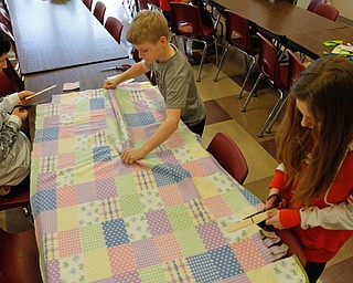      ROBERT K. YOSAY  | THE VINDICATOR..straightening - measuring and cutting is  (starting at 90 oclock and clockwise) Noah Pecchia 14 8th grade A J  Barber 6th grade 11 and Kayelyn Crofford 12 6th grade ... St. Charles School students huddled around tables in the cafeteria busying themselves with measuring, cutting and tying for a good cause..The fifth-through-eighth-graders were making blankets Tuesday morning for Making Kids Count, a nonprofit organization that helps children in Mahoning, Trumbull, Columbiana, Ashtabula and Portage counties..--30-...