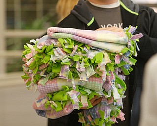      ROBERT K. YOSAY  | THE VINDICATOR..Carrying  several blankets -  is  Louie Gentile an 8th grader..St. Charles School students huddled around tables in the cafeteria busying themselves with measuring, cutting and tying for a good cause..The fifth-through-eighth-graders were making blankets Tuesday morning for Making Kids Count, a nonprofit organization that helps children in Mahoning, Trumbull, Columbiana, Ashtabula and Portage counties..--30-...