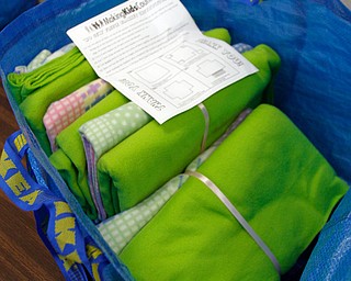      ROBERT K. YOSAY  | THE VINDICATOR..Blankets wrapped in ribbon ready to go..St. Charles School students huddled around tables in the cafeteria busying themselves with measuring, cutting and tying for a good cause..The fifth-through-eighth-graders were making blankets Tuesday morning for Making Kids Count, a nonprofit organization that helps children in Mahoning, Trumbull, Columbiana, Ashtabula and Portage counties..--30-...