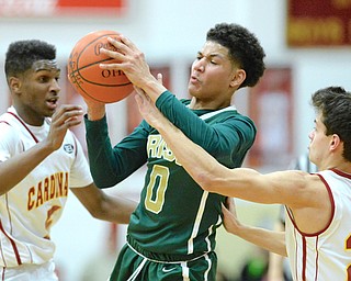 Jeff Lange | The Vindicator  FRI, FEB 5, 2016 - Usuline's Mike Hughes (0) maintains possession of the ball under the pressure of Cardinals' Trell Thomas (left) and Justin Lanzo (right) in the first half of their matchup at Cardinal Mooney High School on Friday.